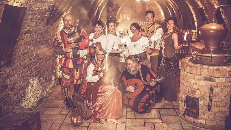 Eine Menschengruppe mit Kleidung aus dem Mittelalter im Keller