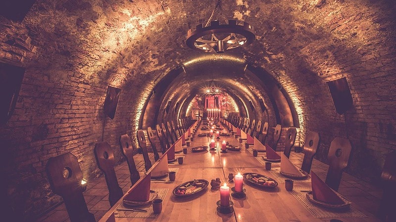 Sehr langer und gedeckter Tisch im Keller aus dem Mittelalter