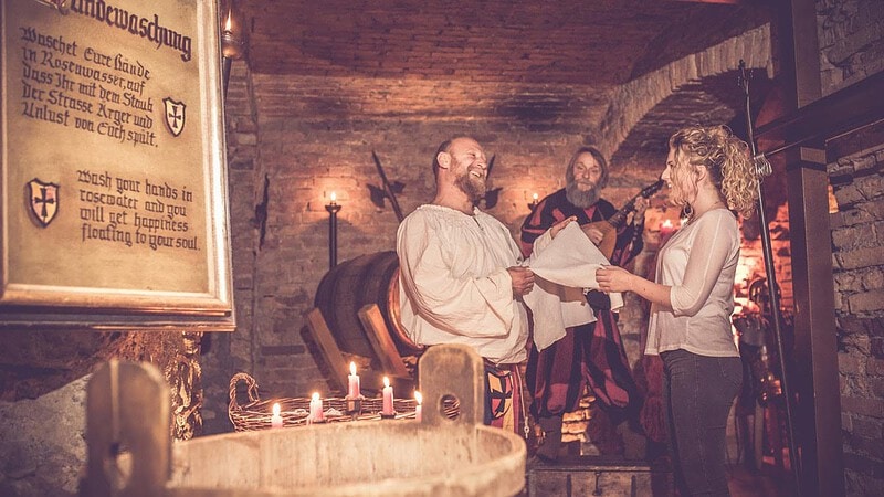 Mann reicht Frau Handtuch die sich die Hände im altmodischen Becken gewaschen hat