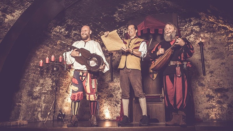 Drei Männer die Kleidung aus dem Mittelalter tragen und Musikinstrumente haben