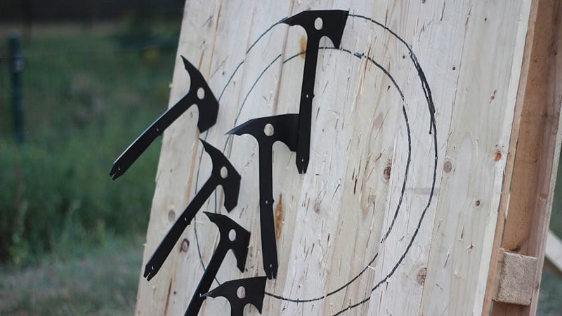 Sechs Äxte, steckend in einer Zielscheibe.