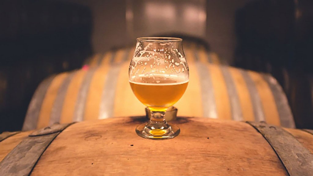 Biertasting_Chemnitz_4.jpg Glas Bier steht auf Holzfass zum Bier Tasting in Chemnitz