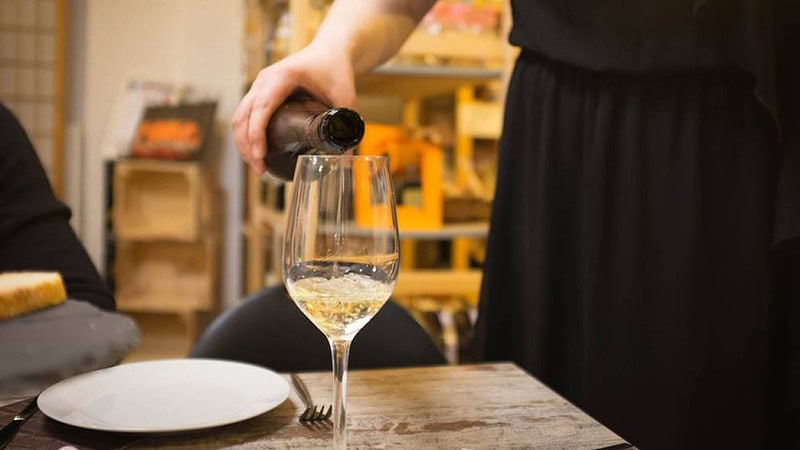 Weißwein wird in ein Glas gefüllt