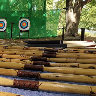 Bogenschießen in Berlin Viele Bögen und drei Zielscheiben Viele nebeneinander liegende Bögen und drei Zielscheiben.
