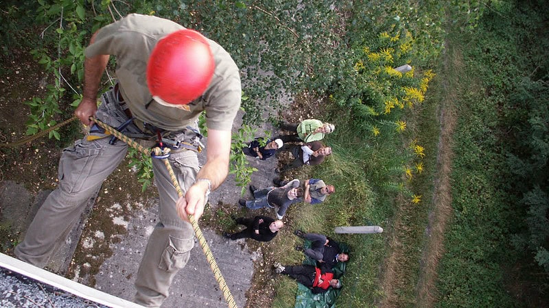 Mann beim Klettern, gesichert und mit Helm