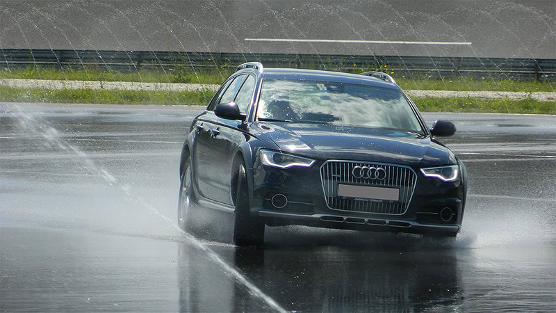Ein Audi driftet auf einer nassen Fahrbahn.