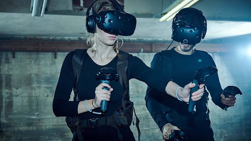 Zwei Personen mit VR-Brillen und Controllern im Escape Room - Virtual Reality (VR) in Berlin