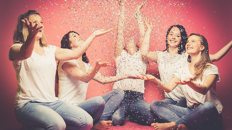 Frauen werfen mit Konfetti hoch zur Fotoparty