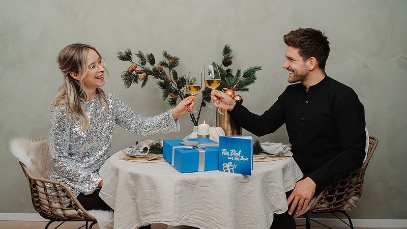 Ein lächelndes Paar freut sich über bei einem Glas Wein.