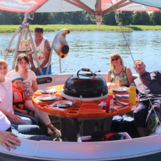 Gruppe sitzt im Grillboot in der Runde für die Grillboot Tour Pizzafahrt in Dresden