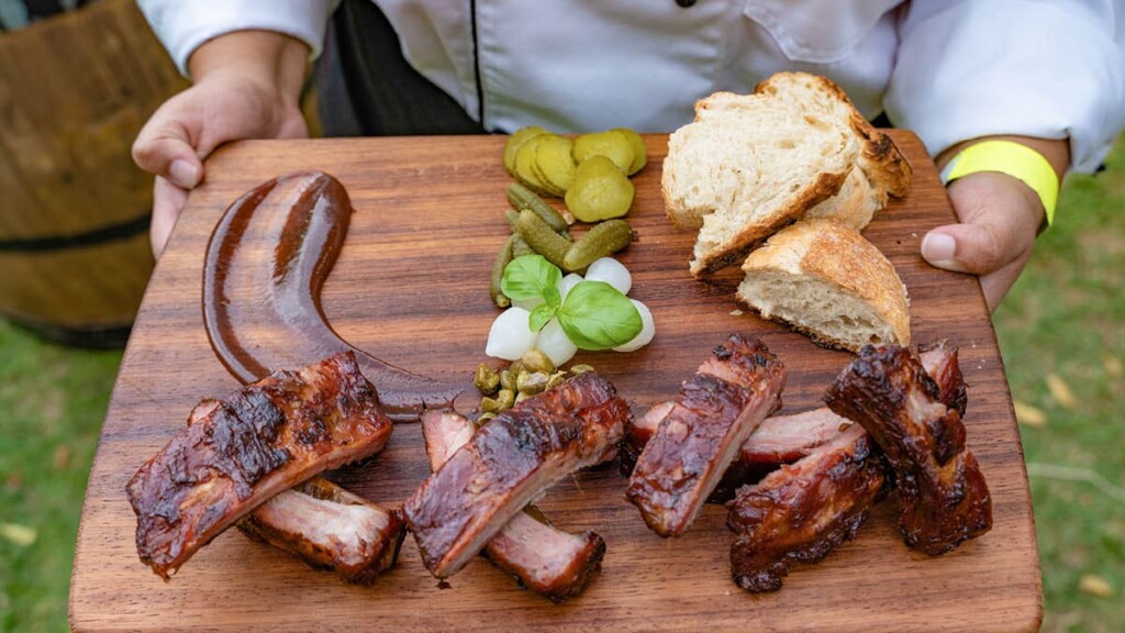 Grillviertell15.jpg Die Hand hält ein Brett mit Brot, Fleisch und Gemüse