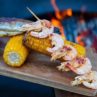 Gegrillter Fisch, Garnelen und Mais auf einem Brett