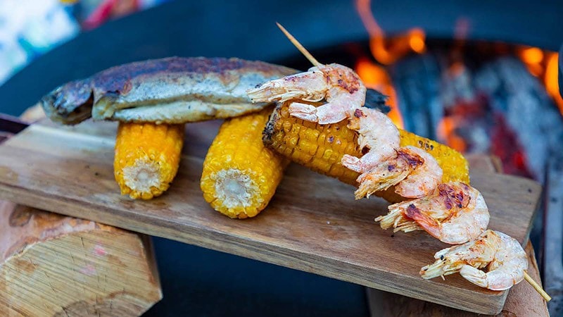 Gegrillter Fisch, Garnelen und Mais auf einem Brett