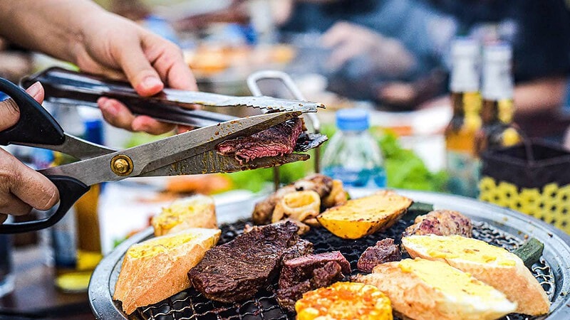 Die Person schneidet Steakfleisch mit der Schere