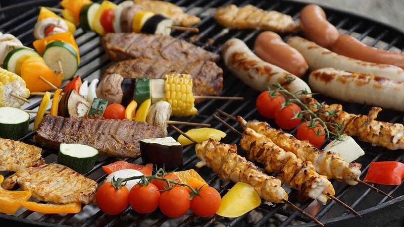 Verschiedene bunte Gemüse und Fleischarten auf einem Grill