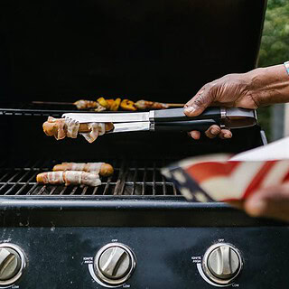 Ein Mann grillt Fleisch auf einem Gasgrill