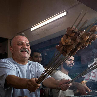 Männer grillen Schaschlik