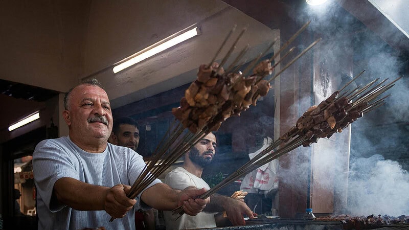 Männer grillen Schaschlik