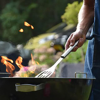 Eine Person grillt auf einem Grill im Garten