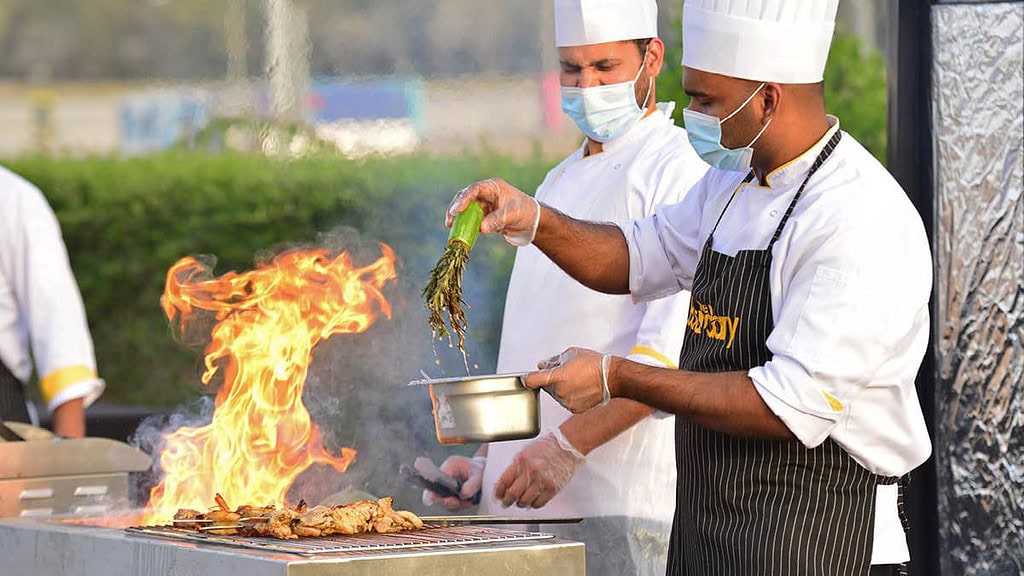 Zwei Köche grillen Gemüse zusammen