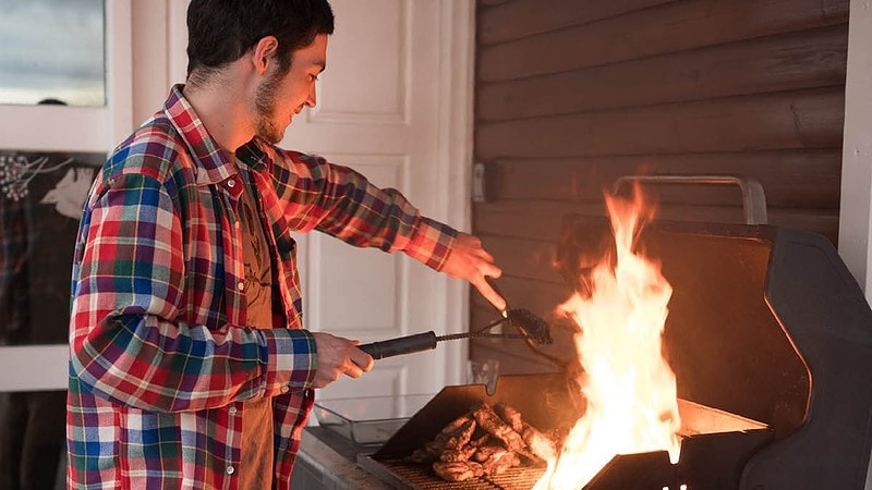 Ein Mann grillt auf einem Grill