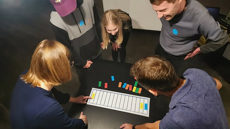 Fünf Personen spielen eines der Wissensspiele bei Hall of Game in Dresden.