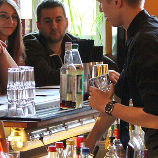 Barkeeper an der Bar vür Gästen des Cocktail Aufbaukurs in Dresden
