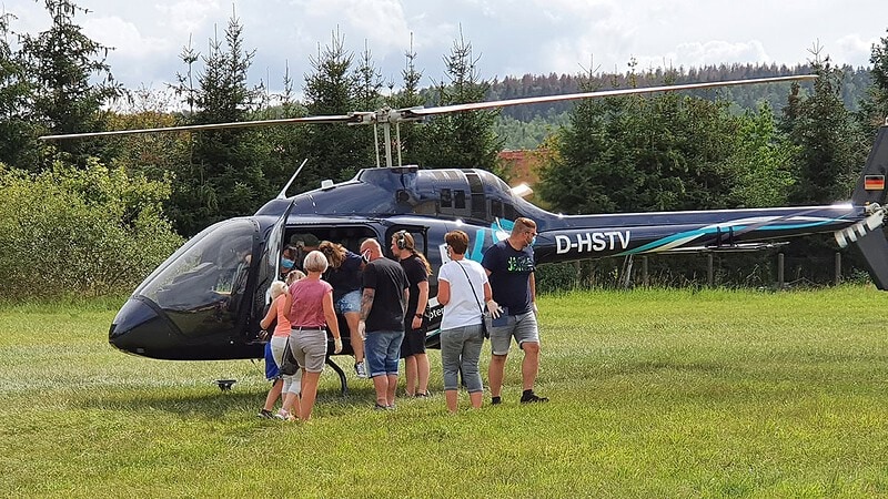 Personen steigen in Hubschrauber für Rundflug