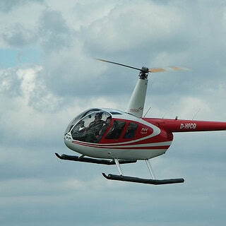 Roter Hubschrauber, fliegt, weiße Wolken, blauer Himmel