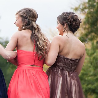 3 Frauen in Kleidern, die linke ein Blaues, die mittlere ein Pinkes und die rechte ein braunes