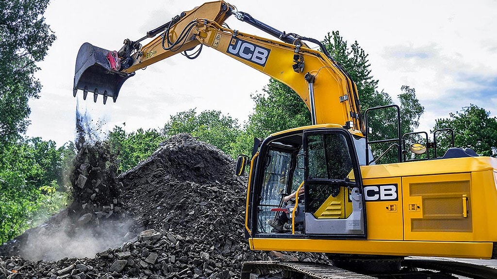 Kettenbagger.jpg Ein Kettenbagger schüttet mit seiner Schaufel steine aus. - Kettenbagger fahren in Wuppertal