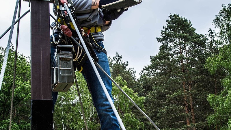 Mann am Seil auf einem Kletterpodest während des Klettererlebnis bei Berlin Bergwelt