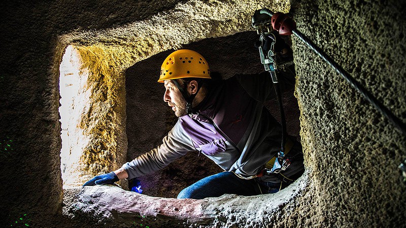 Mann klettert am Seil durch Höhle während des Klettererlebnis bei Berlin Bergwelt