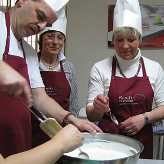Personen rühren in der Schüssel beim Kochkurs in Dresden