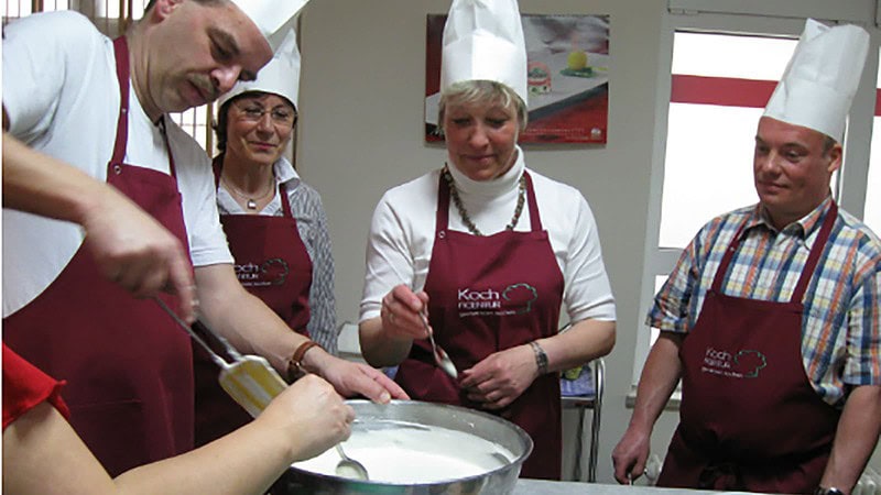 Personen rühren in der Schüssel beim Kochkurs in Dresden
