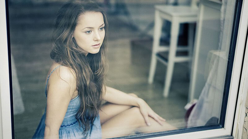 Frau sitzt am Fenster für ein Lifestyle Fotoshooting für Verliebte in Dresden