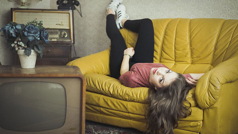 Frau liegt auf gelben Sofa für ein Lifestyle Fotoshooting für Verliebte in Dresden