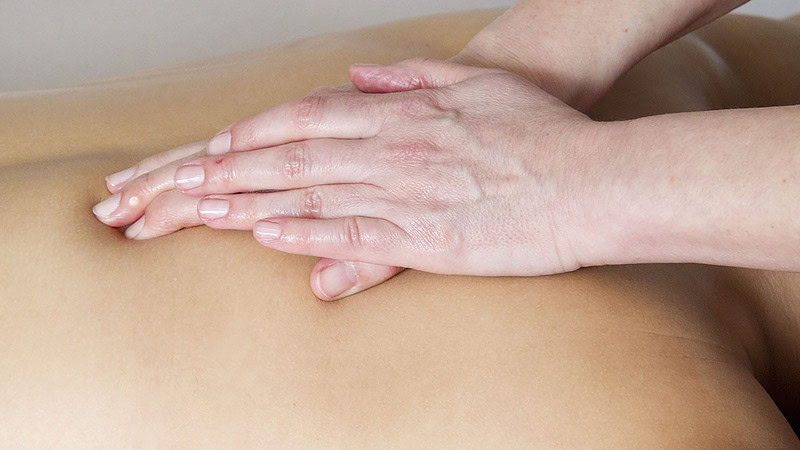 Hände massieren Rücken bei der Ayurveda Massage in Chemnitz