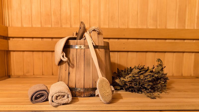 ein Saunaaufguss mit Handtüchern und Kräutern