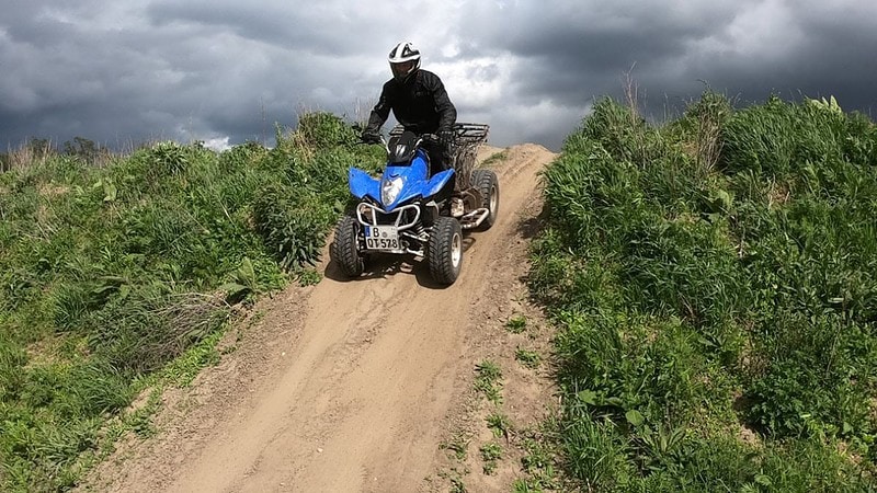 Quad fährt bei Berlin über einen Hügel