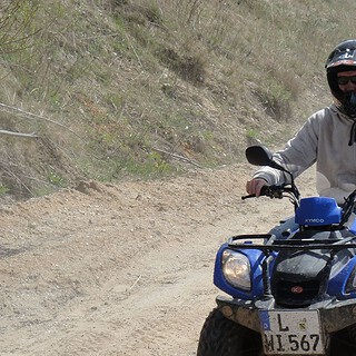 Mann fährt bei Quadtour einen Sandweg entlang