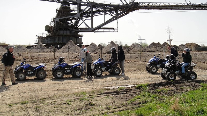 mehrere Personen mit Quads stehen bei der Quadtour vor Sandhügel