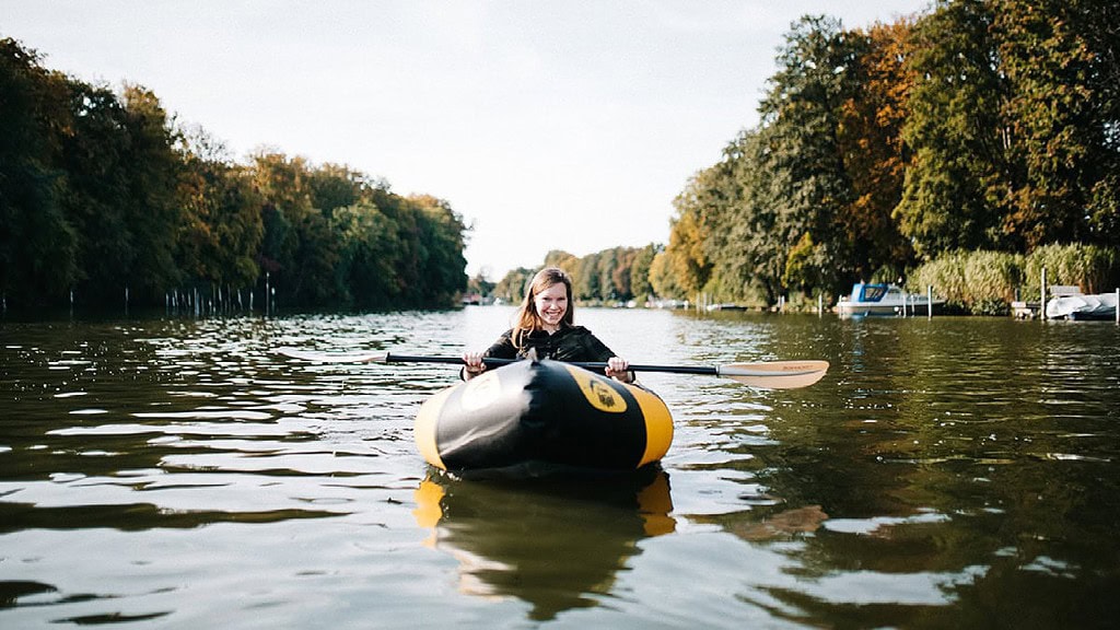 Schlauchboot-Packraft-mieten22.jpg Schlauchboot mieten - Packraft auf dem Wasser mit Frau, die in die Kamera schaut und lächelt