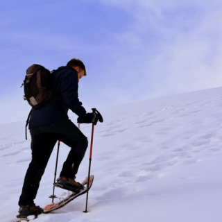 Schneeschuh Tour verschenken - Mann auf einem Berg mit Schnee