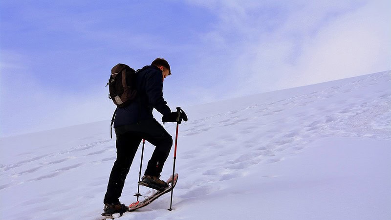 Schneeschuh Tour verschenken - Mann auf einem Berg mit Schnee