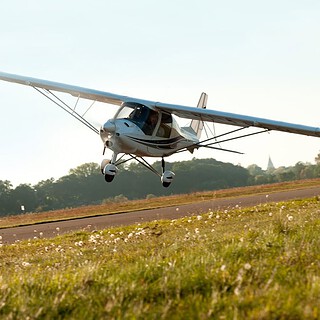 Schnupperkurs-Flugzeug-selber-fliegen_2.jpg Ultraleichtflugzeug über wiese beim Schnupperkurs Flugzeug selber fliegen