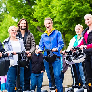 Sechs lächelnde Menschen auf Segways