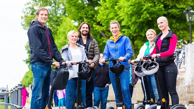 Sechs lächelnde Menschen auf Segways