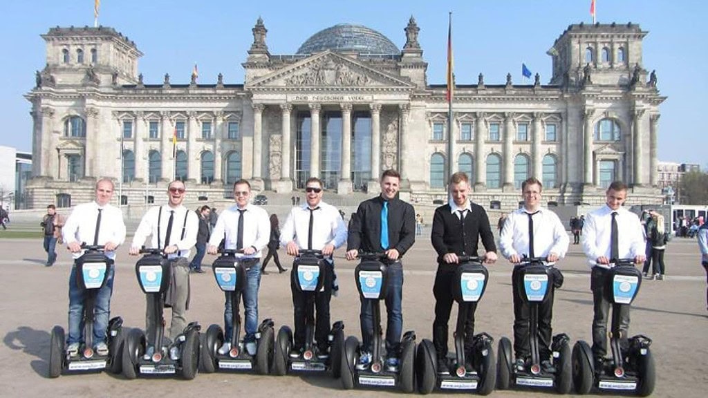 Segwaytour_Gross_Berlin_3neu.jpg Männer stehen auf Segway vor dem Bundestag während der Segway Tour Auf den Spuren des dritten Reiches