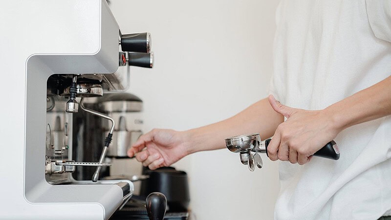 man sieht eine Hand, die gerade eine Siebträgermaschine vorbereitet- Sensorikkurs mit Cupping in Dresden